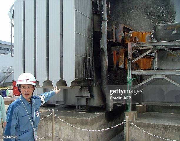Staff of Tokyo Electric Power's Kashiwazaki-Kariwa nuclear plant shows 29 August 2007 a burned out wall after a massive earthquake hit kashiwazaki...