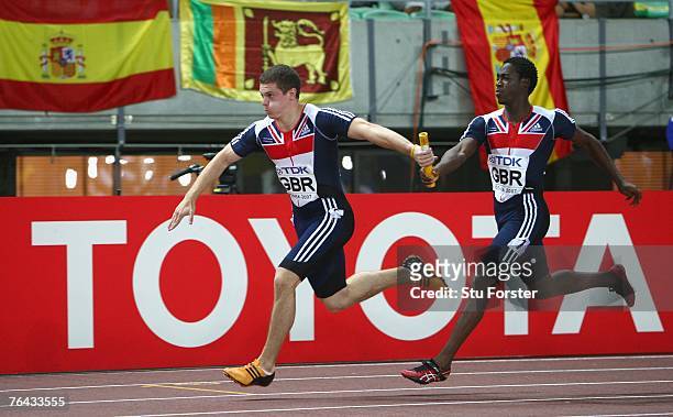 Craig Pickering of Great Britain receives the baton from Christian Malcolm of Great Britain during the Men's 4 x 100m Relay First Round on day seven...