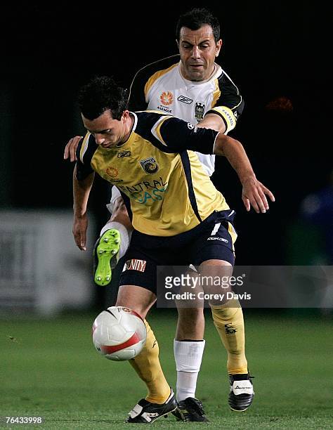 John Hutchinson of the Mariners is challenged by John Aloisi of the Phoenix during the round two Hyundai A-League match between the Central Coast...