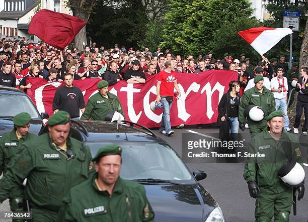 Supporters of Kaiserslautern walk to the stadium sorriunded by police prior to the Second Bundesliga match between TuS Koblenz and 1. FC...
