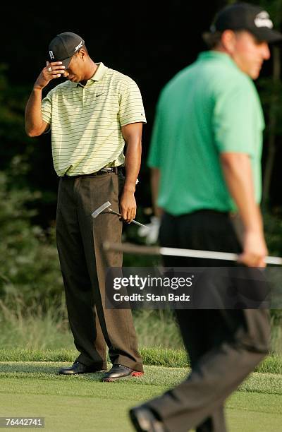 Tiger Woods reacts to his missed putt at the 18th green during the first round of the Deutsche Bank Championship at TPC Boston on August 31, 2007 in...