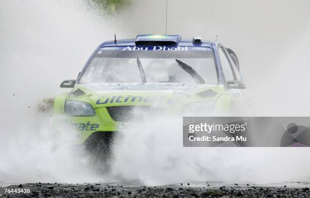 Marcus Gronholm of Finland and co-driver Timo Rautiainen of Finland and the BP Ford World Rally team drive their Ford Focus RS through the water...