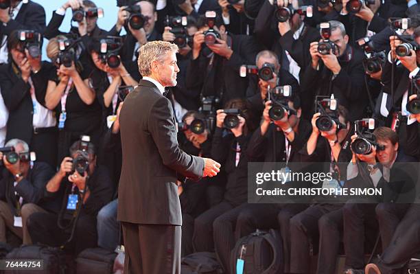 Actor George Clooney ajusts his jacket as he arrives for the screening of the movie in competition "Michael Clayton" at the 64th Venice International...