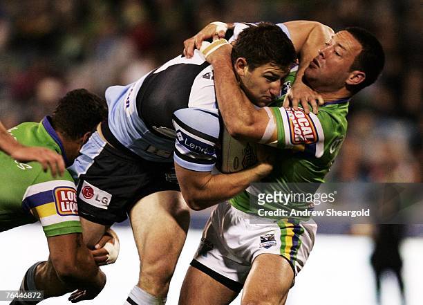 Loncoln Withers of the Canberra Raiders tackles Mitch Brown of the Cronulla Sharks during the round 25 NRL match between the Canberra Raiders and the...