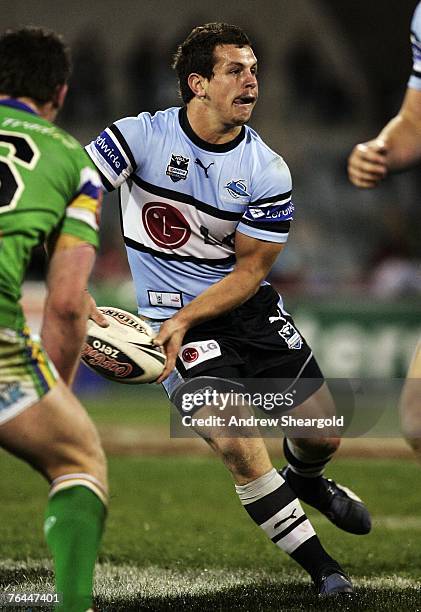 Greg Bird of the Cronulla Sharks passes the ball during the round 25 NRL match between the Canberra Raiders and the Cronulla-Sutherland Sharks at...