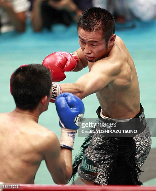 Champion Yutaka Niida of Japan lands his left straight on challenger Eriberto Gejon of the Philippines during the WBA minimumweight title match in...