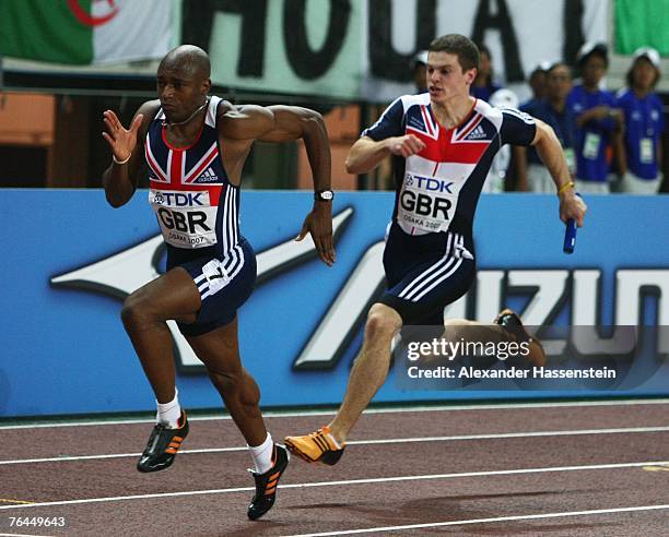 Craig Pickering of Great Britain prepares to hand the baton to team mate Marlon Devonish during the Men's 4 x 100m Relay on day eight of the 11th...