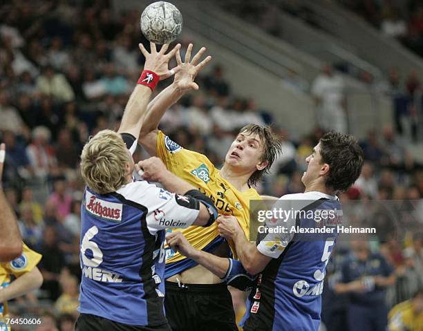 SergeJ Harbok of the Rhein-Neckar Loewen competes with Daniel Sauer and Benjamin Herth of Balingen during the Handball- Bundesliga match between...