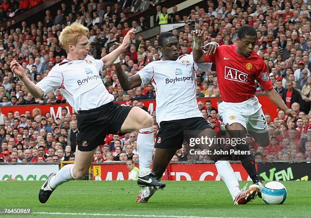 Patrice Evra of Manchester United clashes with Paul McShane and Nyron Nosworthy of Sunderland during the Barclays FA Premier League match between...