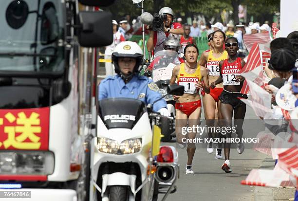 Marathon women athletes China's Chunxiu Zhou, Chinese Xialin Zhu and Kenyan Catherine Ndereba run through Osaka streets during the 11th IAAF World...