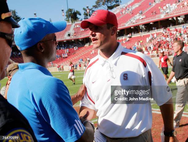 Head coach Karl Dorrell of the UCLA Bruins and head coach Jim Harbaugh of the Stanford Cardinal exchange a handshake after the UCLA 45-17 defeat of...