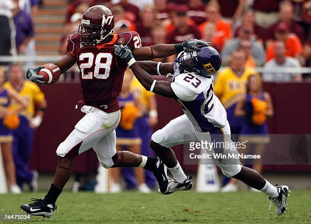 Running back Branden Ore of the Virginia Tech Hokies stiff arms defensive back Dekota Marshall of the East Carolina Pirates in fourth quarter action...