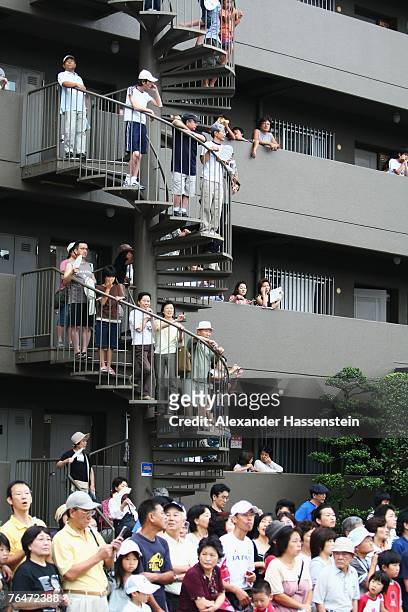 Spectators watch from buildings as the athletes make their way through the streets of Osaka while competing in the Women's Marathon on day nine of...