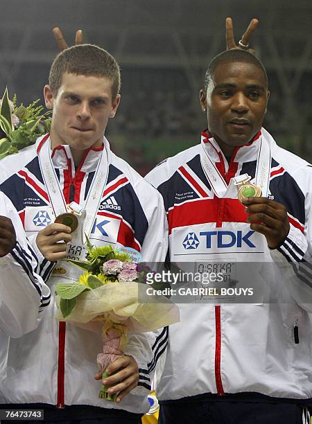 Britain's Craig Pickering and Mark Lewis-Francis pose as Jamaica's Usain Bolt makes a sign behind them during the men's 4x100m relay medal ceremony...
