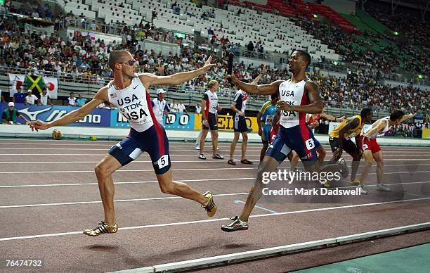 Jeremy Wariner of the United States of America receives the baton from team mate Darold Williamson during the Men's 4 x 400m Relay Final on day nine...