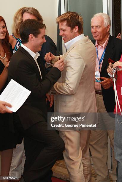 Brad Pitt gives his sunglasses to Casey Affleck after photographers threaten to walk out of The Assassination of Jesse James by the Coward Robert...