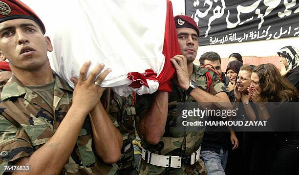Women cry in mourning as Lebanese soldiers carry the coffin of army officer Ali Nassar during a funeral procession in the village of Kfar Hata south...