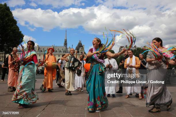 iskcon devotees performing a harinam (devotional walk with dancing and chanting) in paris. france. - associazione internazionale per la coscienza di krishna foto e immagini stock