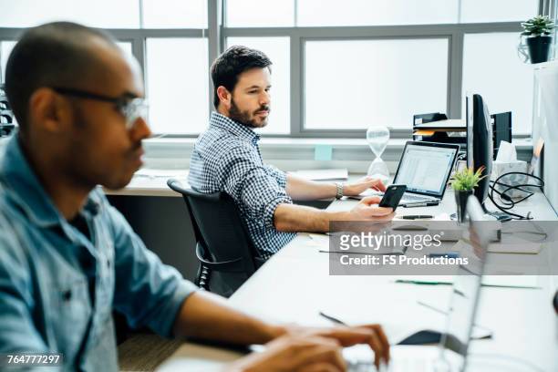 businessmen using technology in office - answering stock pictures, royalty-free photos & images