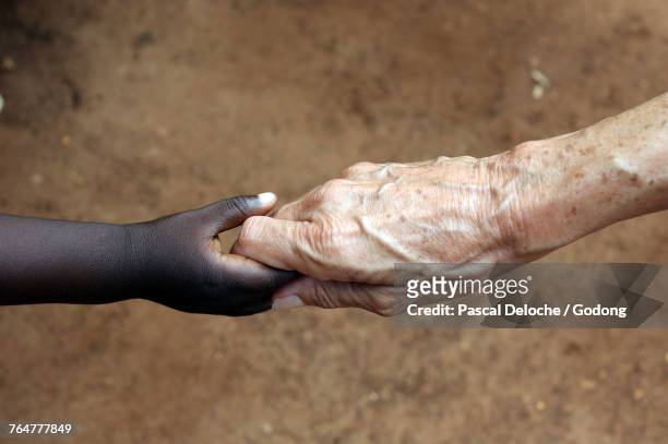 humanitarian worker holding childs hand. togo. - togo stockfoto's en -beelden