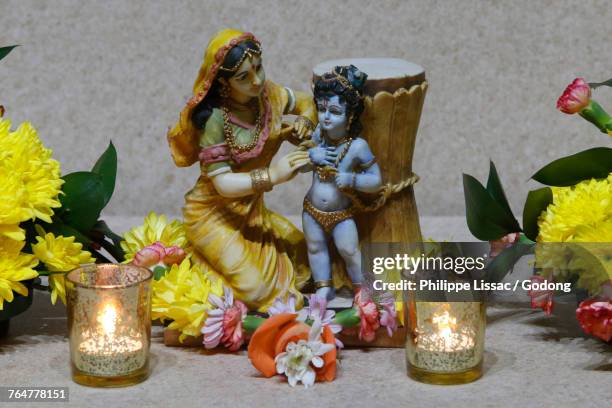 statues and flowers in the leicester iskcon temple. krishna with his mother. united kingdom. - krishna bildbanksfoton och bilder