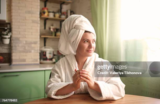 caucasian woman in bathrobe and towel warming hands on cup - towel 個照片及圖片檔