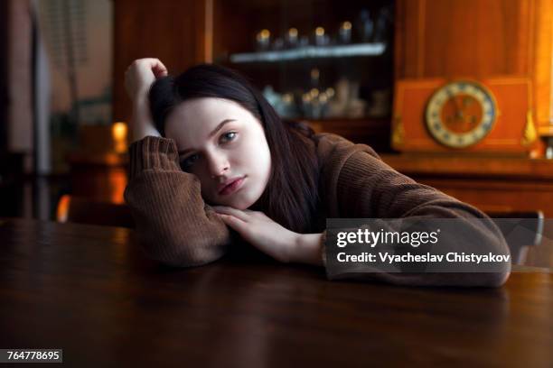 depressed caucasian girl leaning on table - black hair stock pictures, royalty-free photos & images