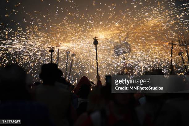 crowd watching sparks in parade at night - correfoc stock pictures, royalty-free photos & images