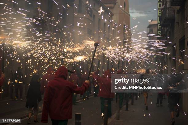 crowd carrying torches with sparks in parade at night - correfoc stockfoto's en -beelden