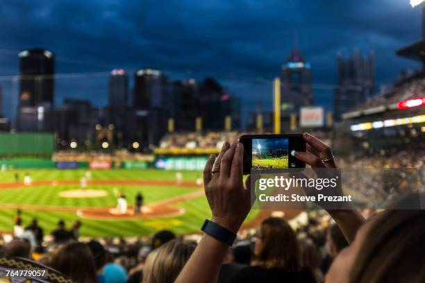 hands of woman photographing baseball game with cell phone - baseball stadium photos et images de collection