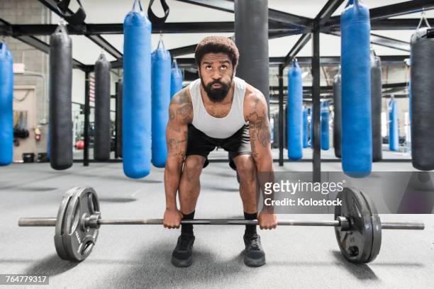 black man lifting barbell in gymnasium - weightlifting imagens e fotografias de stock