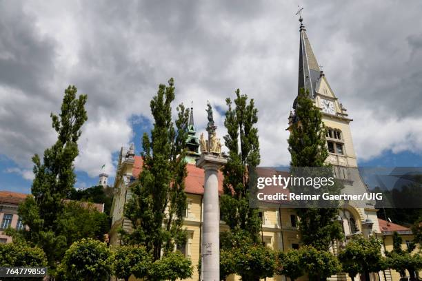 st james parish catholic church and st. marys column of the virgin in brass and stone statues - jesuit stock-fotos und bilder