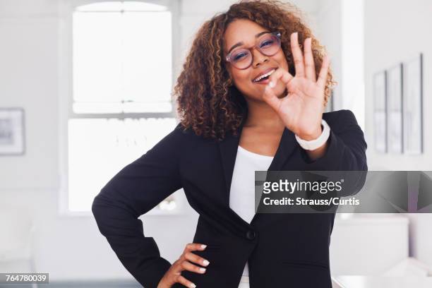 mixed race woman gesturing okay in gallery - gesturing ok stock pictures, royalty-free photos & images
