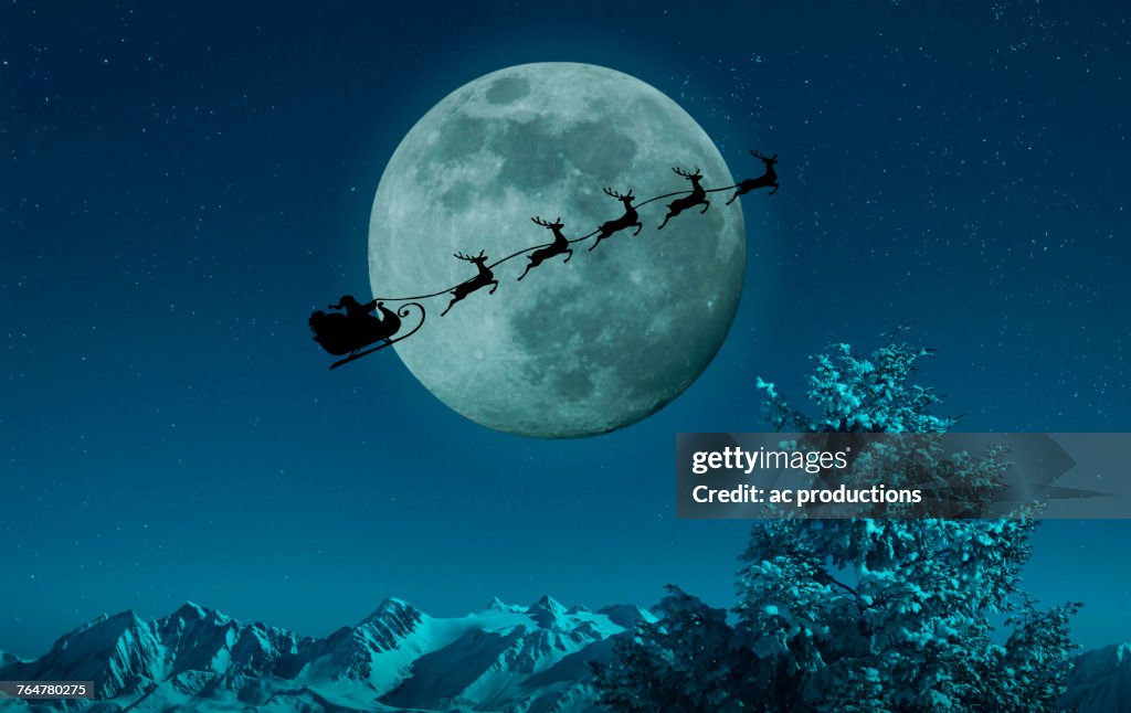 Silhouette of Santa and reindeer flying sleigh near full moon