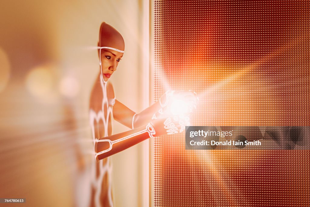 Light glowing in hands of futuristic woman emerging from wall