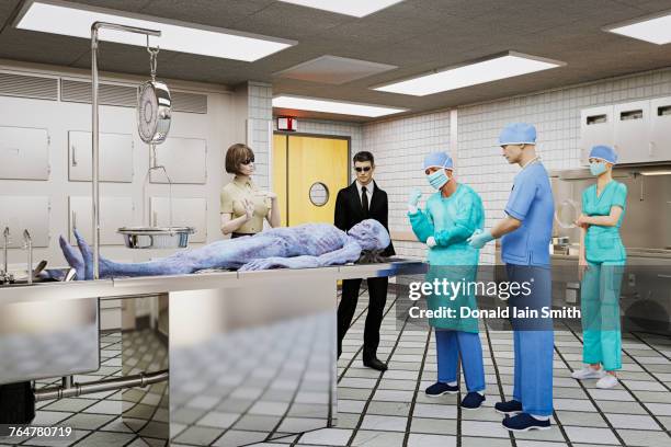 government and doctors examining dead alien - autopsie stock-fotos und bilder