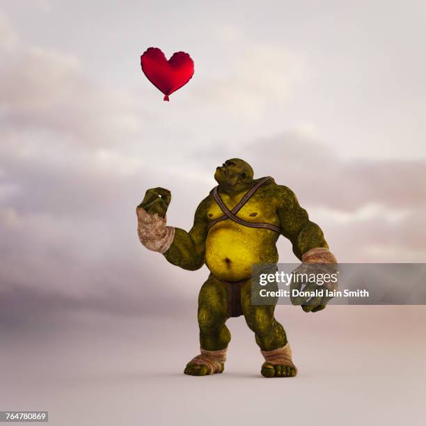 angry ogre looking up at floating red balloon heart - ogre fictional character fotografías e imágenes de stock