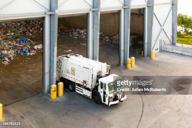 garbage truck unloading trash - garbage truck fotografías e imágenes de stock