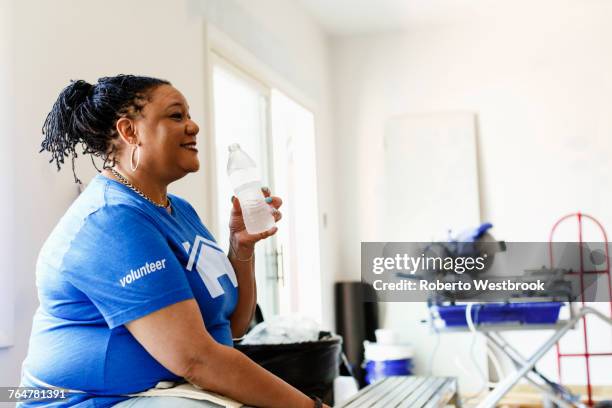 black volunteer woman drinking water - welfare reform stock pictures, royalty-free photos & images