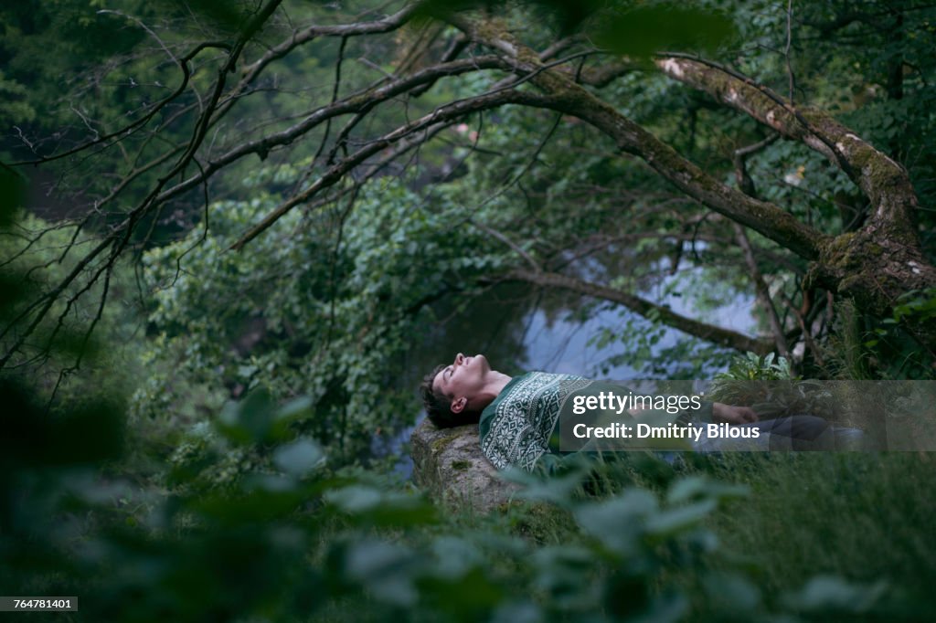 Caucasian man relaxing in woods