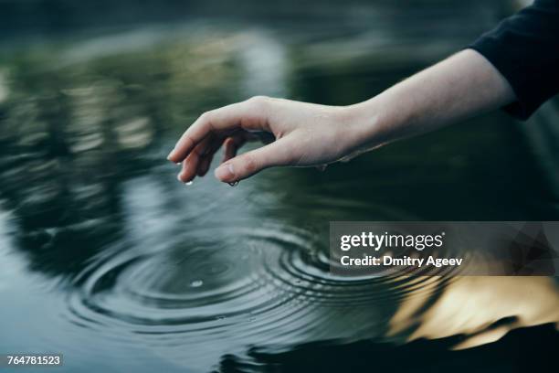 water dripping from hand of woman - middle finger stock-fotos und bilder