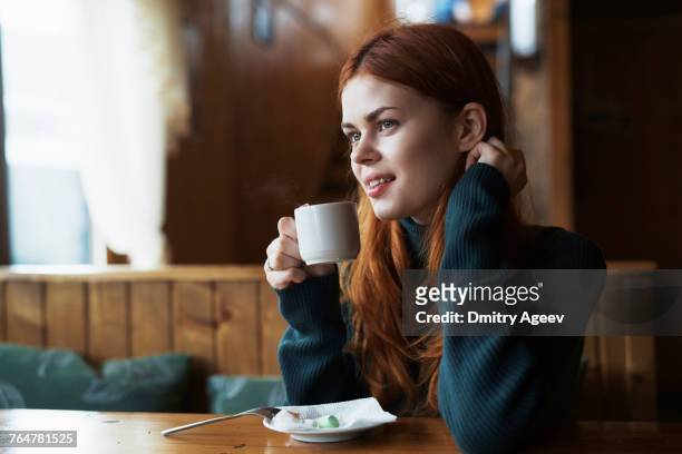 smiling woman drinking coffee in cafe - マグカップ ストックフォトと画像