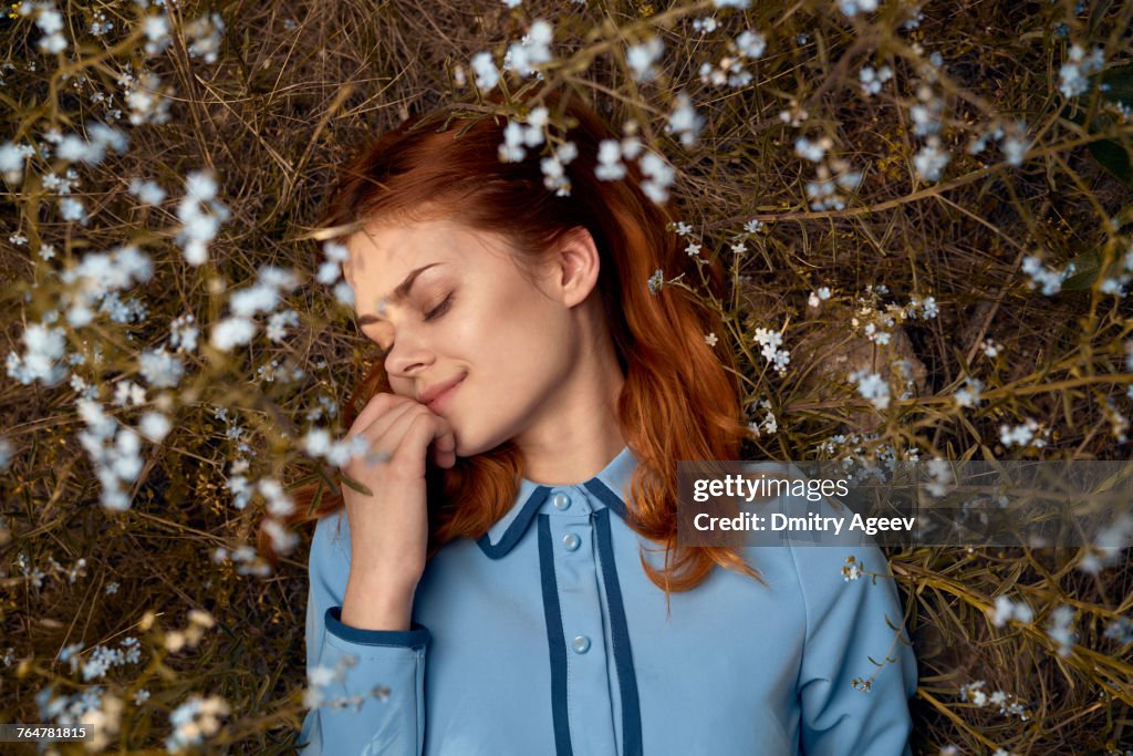 Caucasian woman laying in field of wildflowers