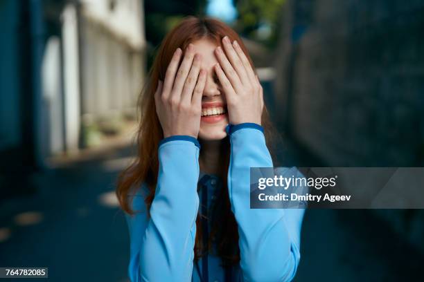 caucasian woman covering eyes with hands - hidw and seek stock pictures, royalty-free photos & images