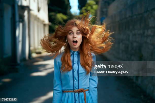 wind blowing hair of surprised caucasian woman - faszination stock-fotos und bilder