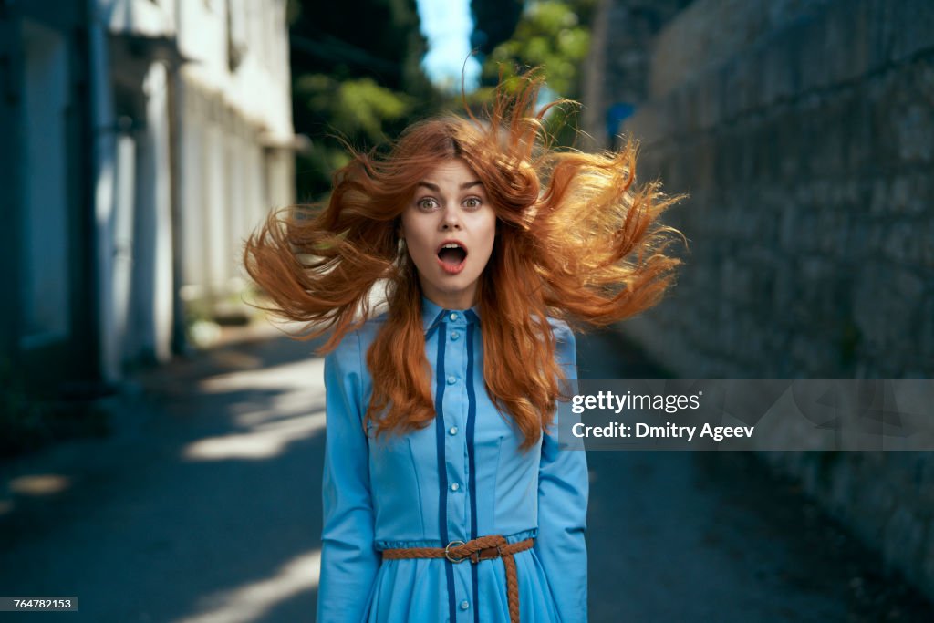 Wind blowing hair of surprised Caucasian woman