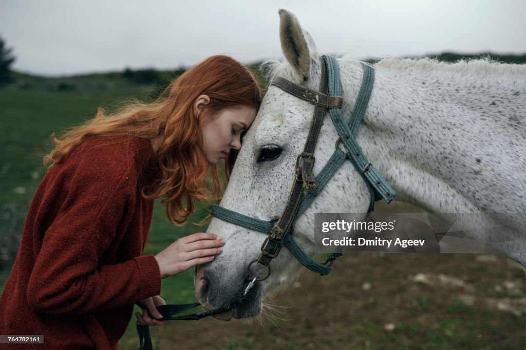 Caucasian woman petting horse