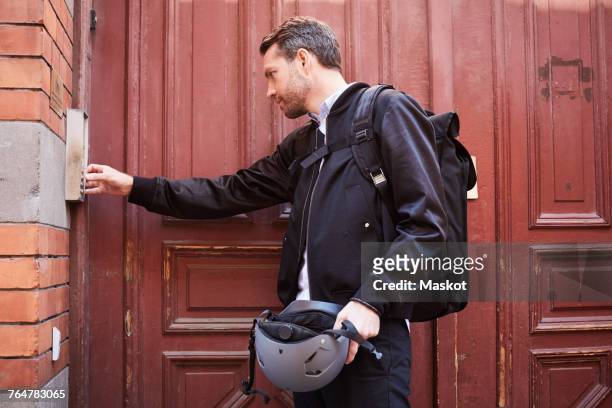 businessman with backpack entering keycode to close wooden door - code 41 stock pictures, royalty-free photos & images