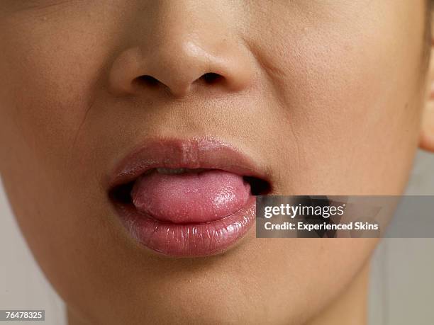 close-up of woman sticking out her tongue - ugly tongue stock pictures, royalty-free photos & images