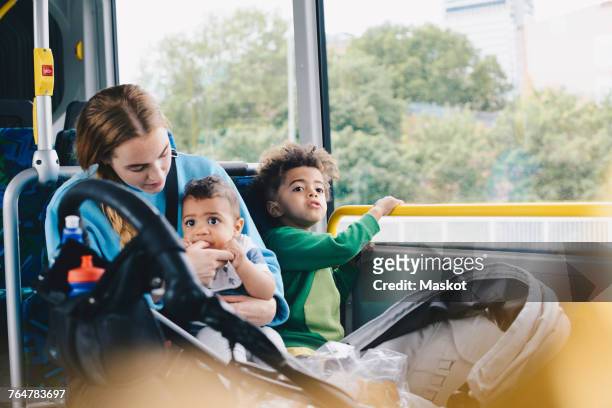 mother sitting with sons in bus - kids sitting together in bus stock pictures, royalty-free photos & images